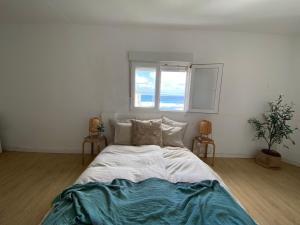 Cama grande en habitación con ventana en Nueve Pies Surf house, en Las Palmas de Gran Canaria