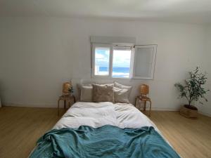 a large bed in a room with a window at Nueve Pies Surf casita in Las Palmas de Gran Canaria