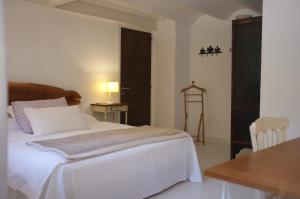 a bedroom with a white bed with a table and a table sidx sidx at Acogedora casa en la montaña in La Baronia de Rialb +83 photos