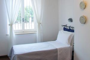 1 dormitorio con cama blanca y ventana en Hotel Premuda, en Spotorno