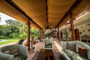 an outdoor living room with couches and chairs at Rukka Lodge in Tumbaco