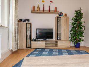 - un salon avec une télévision sur un centre de divertissement en bois dans l'établissement Apartment Nordlicht by Interhome, à Bremerhaven