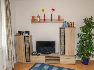 a television sitting on a wooden entertainment center in a living room at Apartment Nordlicht by Interhome in Bremerhaven