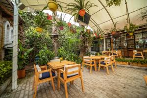 un ristorante con tavoli e sedie in legno e piante di Rukka Lodge a Tumbaco