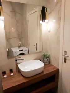 un bagno con un grande lavandino bianco su un bancone in legno di SITIA CITY CENTER luxury apartment a Sitia