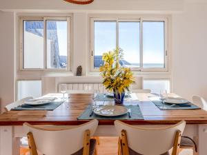 a dining room with a table and chairs and windows at Apartment Les Mouettes by Interhome in Jullouville-les-Pins