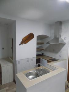 a kitchen with a sink and a wooden object on the wall at Hotel Rural SUEÑOS DEL QUIJOTE in Madridejos