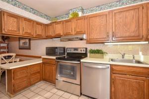 a kitchen with wooden cabinets and a stove top oven at Seven Springs 3 Bedroom Standard Townhouse, Sleeps 11! condo in Champion