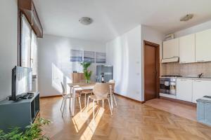 uma cozinha e sala de jantar com uma mesa e uma televisão em Parma Parco Ducale Duplex Apartment with parking em Parma