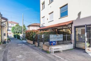 un edificio con un cancello e una panchina di fronte ad esso di Parma Parco Ducale Duplex Apartment with parking a Parma