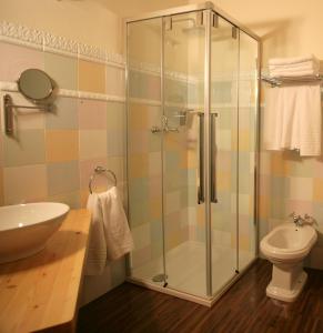 a bathroom with a toilet a sink and a shower at Hotel Balneario La Hermida in La Hermida