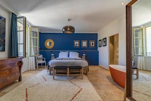 Marcelle en Camargue في إج مورت: غرفة نوم مع سرير وحوض استحمام في غرفة