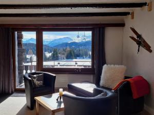 sala de estar con ventana grande con vistas a la montaña en Apartment Stgirat Bellaval by Interhome, en Valbella