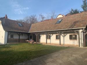 a house with a roof with a picnic table in the yard at Kusper Vendégház 1846 in Bükkzsérc