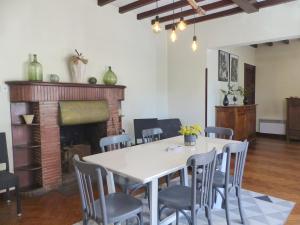 a dining room with a table and chairs and a fireplace at Villa DOUS REPAOUS pour 5 personnes entre lac et océan in Soorts-Hossegor
