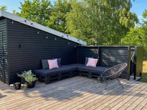 una panchina e una sedia su una terrazza di legno di Holiday Home Aida - 400m from the sea in Bornholm by Interhome a Rønne