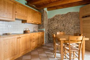 a kitchen with wooden cabinets and a wooden table at Civico 12 in Marmora +6 photos