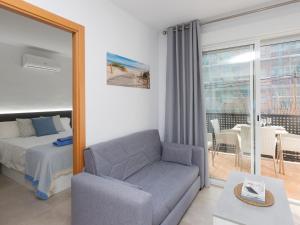1 dormitorio con sofá, cama y balcón en Apartment Karma by Interhome, en Segur de Calafell