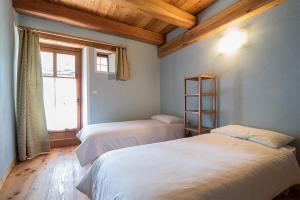 two beds in a room with a window at Civico 11 in Marmora