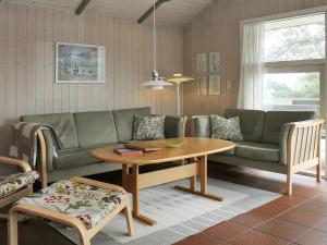 ein Wohnzimmer mit einem Sofa und einem Tisch in der Unterkunft Holiday Home Aasa - 200m from the sea in Western Jutland by Interhome in Fanø