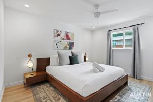 a white bedroom with a large bed and a window at Insta-Ready Apartment in Barton Hills w King Bed in Austin