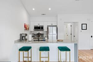 a kitchen with a counter with two green stools at Insta-Ready Apartment in Barton Hills w King Bed in Austin