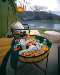 Juances的住宿－Luzada - Glamping Burbujas Galicia，帐篷里桌子上的托盘食物