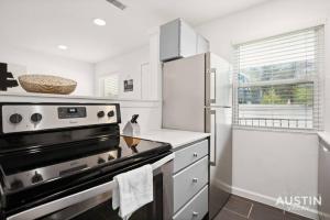 a kitchen with a stove and a refrigerator at Great Clarksville Condo Near W 6th plus Free Parking in Austin +13 photos