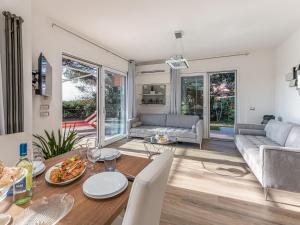 uma sala de jantar e sala de estar com mesa e cadeiras em Holiday Home Villa Marzia Mare & Golf by Interhome em Punta Ala