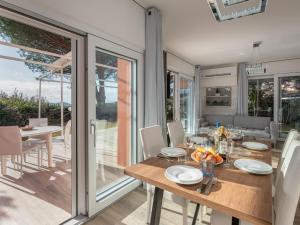 uma sala de jantar com mesa e cadeiras e portas de vidro deslizantes em Holiday Home Villa Marzia Mare & Golf by Interhome em Punta Ala