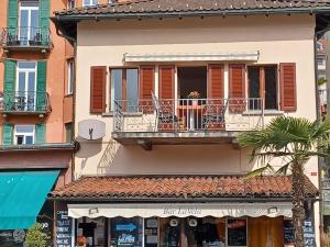 a building with a balcony and a palm tree at Apartment Appartamento da Reto by Interhome in Muralto