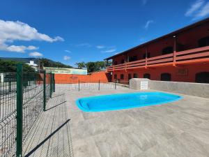 une piscine en face d'un bâtiment dans l'établissement 0001.08 - Maranduba - Apto - 2 Dormitório - 8 Pessoas - 2 Quadras Do Mar - Piscina - Wi-Fi (Excursão 96 Pessoas), à Ubatuba