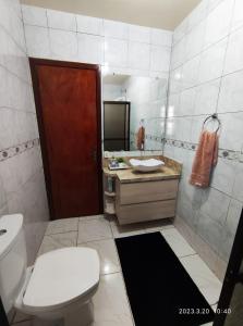 a bathroom with a white toilet and a sink at Pousada com vista para o Cristo 1 in Encantado