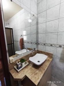 a bathroom with a sink and a mirror at Pousada com vista para o Cristo 1 in Encantado