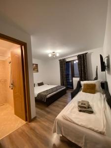 Habitación de hotel con 2 camas y espejo en Casa Moșoiu en Bran