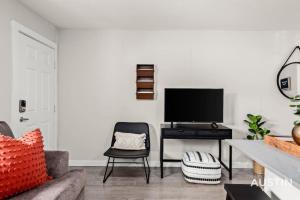 ein Wohnzimmer mit einem Sofa und einem Schreibtisch mit einem TV in der Unterkunft Fun Weekend Getaway Modern Decor, Parking, and Deck in Austin