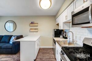 uma cozinha com um lavatório e um sofá num quarto em Get Comfy Memory Foam Beds and Tub in Central ATX em Austin