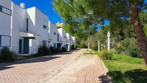 a cobblestone street in front of a white building at Townhouse Prainha Beach in Alvor