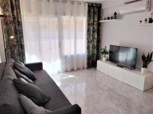 a living room with a couch and a flat screen tv at CAMBRILS BEACH APARTMENT in Cambrils