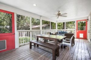 a screened porch with a wooden table and a ceiling fan at Sizable Screened in Porch w Luxury Kitchen and Bath in Austin