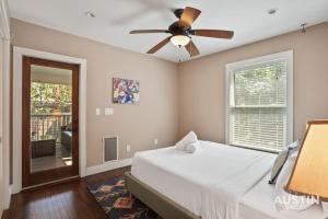 una camera con letto e ventilatore a soffitto di Sizable Screened in Porch w Luxury Kitchen and Bath ad Austin