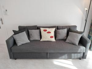 a gray couch with pillows on it in a living room at CAMBRILS BEACH APARTMENT in Cambrils