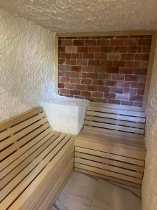 a sauna with two benches in front of a brick wall at STUDIO 33 Luxury&Spa in Zlatibor
