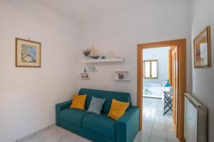 a living room with a blue couch with yellow pillows at Mamma Rosa Be Home in Salerno