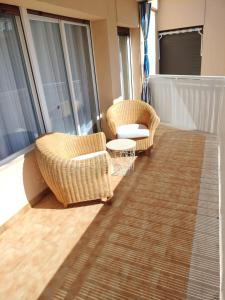 two wicker chairs and a table on a balcony at CAMBRILS BEACH APARTMENT in Cambrils