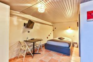 a bedroom with a bed and a table in a room at Gite - Studios Marie Barrault in Les Herbiers