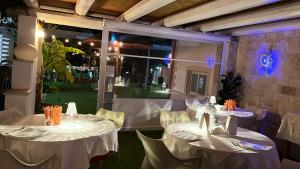 two tables in a restaurant with white table cloth at Spacious apartment in Pozzallo, sea view, shared pool in Pozzallo +24 photos