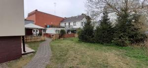 a house with a brick walkway in a yard at Apartamenty Świnoujście - Słowackiego in Świnoujście