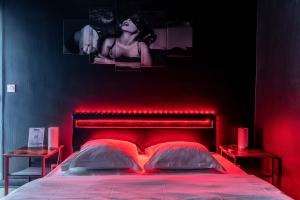 a bedroom with a red bed with two red lights at LOVE ROOM ou pas ! Chamalières in Chamalières