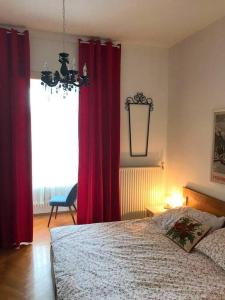 a bedroom with red curtains and a bed and a window at Stilhaus-Zimmer im Herzen des Drautales in Feistritz an der Drau
